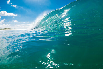 Turquoise beach break wave in ocean. Breaking wave with sunshine
