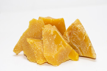 blocks of virgin beeswax stacked on a white background