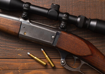 Lever-action hunting rifle and bullets on wood