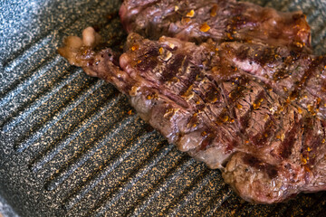 Juicy beef meat steak cooking on griddle pan at professional kitchen. Prime steak frying at grill. Delicious, modern cuisine