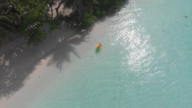 Aerial drone quad copter footage of nice woman girl floating on a lilo inflatable with in tropical waters in maldives of crystal clear waters of an ocean coral reef with palms
