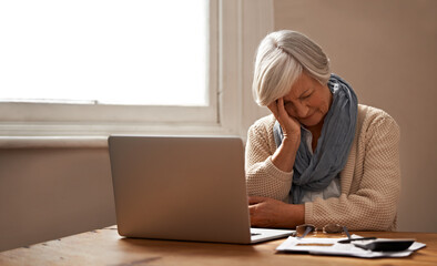 Retirement fund worries.... An elederly woman sitting in front of her laptop looking stressed and...