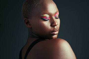 Be different, be unique. Cropped shot of a beautiful woman wearing colorful eyeshadow while posing against a grey background.