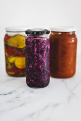 jars with homemade preserved sauerkraut vegetables and tomato chutney, simple ingredients concept