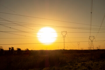 High tension electric line towers landscape at sunset