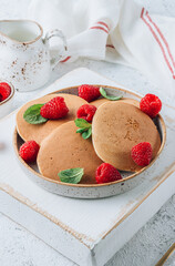 Fresh pancakes for breakfast with raspberry on light background. Summer healthy food