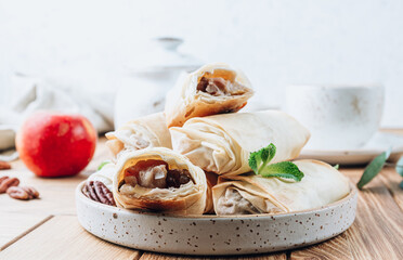 Mini apple strudel with pecans and mint on wooden table. Viennese pastry.