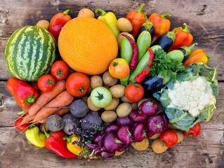 A bunch of colorful vegetables on a wooden surface.