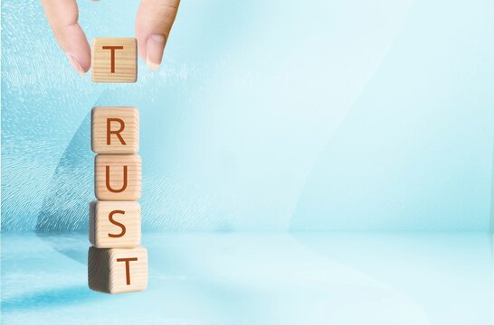 Hand stacking wooden blocks for letters. Build trust concept
