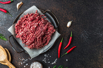 Raw minced beef meat on a tray over black background.
