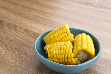 Jagung manis rebus or boiled sweet corn slices served on bowl on wooden background. Space for text. 
