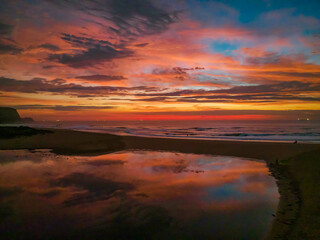 Fototapeta na wymiar Dawn reflections and clouds at the seaside with lagoon