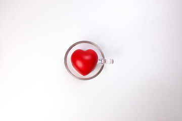 transparent glass coffee tea cup saucer with three dimension 3d red hart symbol inside on white...
