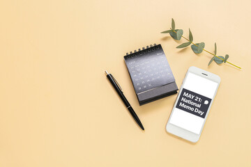 Flip paper calendar, mobile phone and pen on beige background. National Memo Day