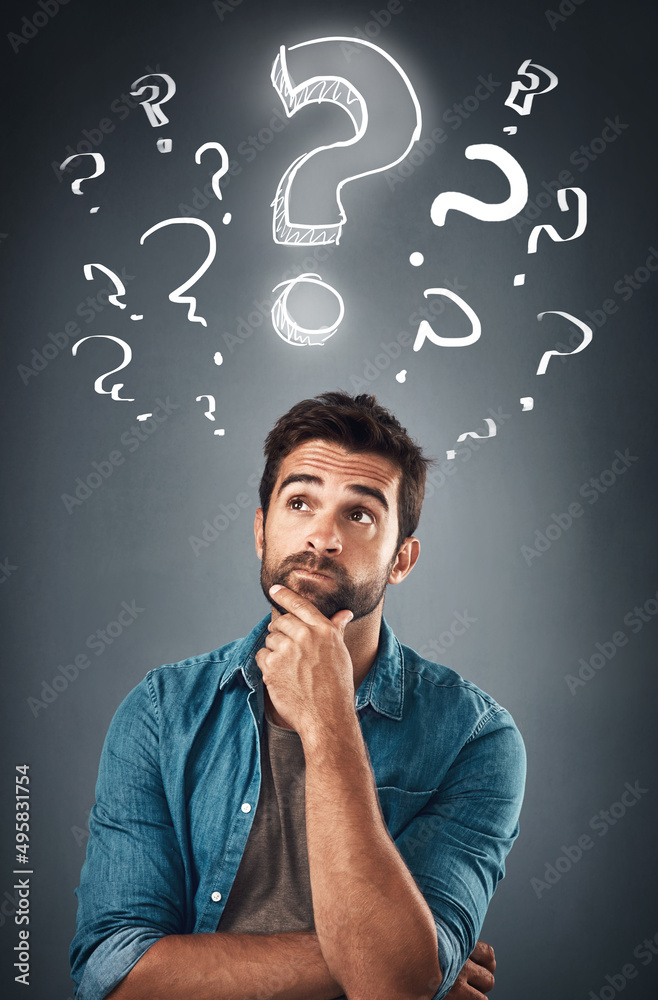 Poster hes full of bright ideas. studio shot of a handsome young man looking thoughtful while standing unde