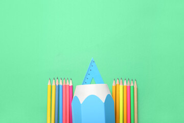 Holder with ruler and pencils on green background