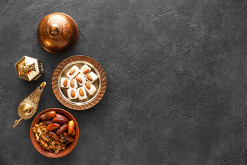 Tasty Eastern sweets and Arabic lamps on dark background