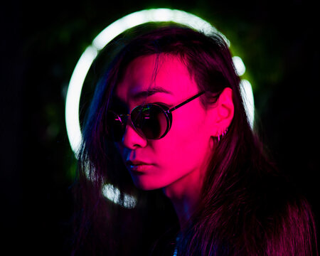 Portrait Of Asian Man Wearing Sunglasses In Neon Light. 