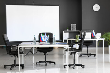 Interior of conference room with Italian, Israel and Russian flags on table