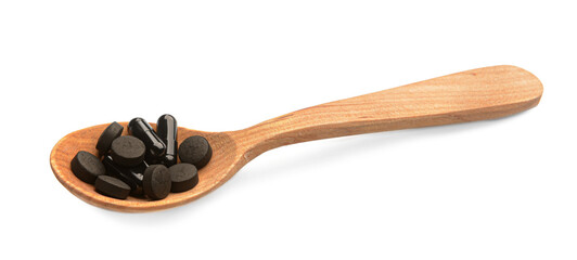 Wooden spoon with activated carbon pills on white background