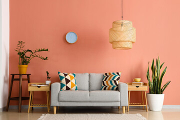 Interior of stylish living room with sofa, wooden table and pink wall