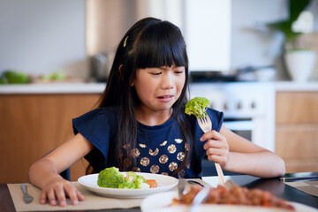 Urgh, I hate the taste of this. Shot of a little girl refusing to eat her broccoli.