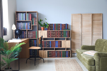 Shelf unit with books and stylish workplace in home library