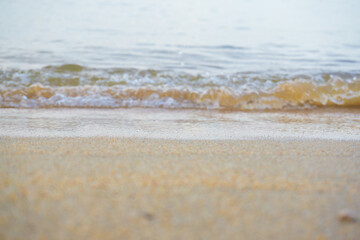 Fototapeta na wymiar Sea wave on sandy beach morning sun light
