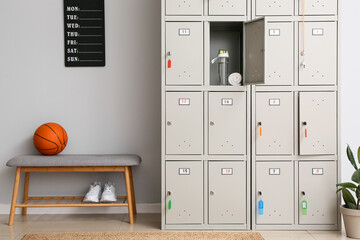 Locker with sport equipment and bench in change-room