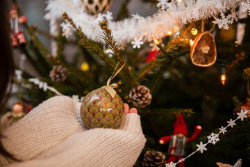 A Christmas tree bauble in a woman's hands during Christmas.