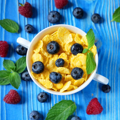 Healthy eating, food and diet concept - Cornflakes with berries and milk for breakfast.