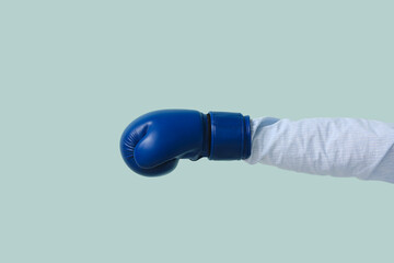 Hand in boxing glove on color background