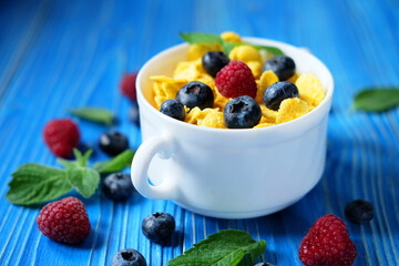 Healthy eating, food and diet concept - Cornflakes with berries and milk for breakfast.