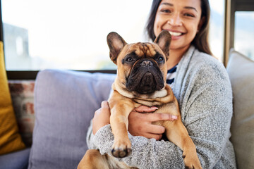 A house is not a home without a cute companion. Portrait of a young woman relaxing with her dog at home.