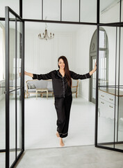 Young  woman in black silk .pajamas possing at home