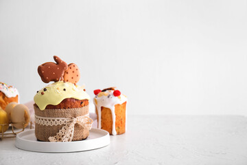 Delicious Easter cakes decorated with cookies on light background