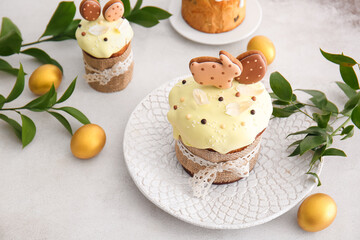 Delicious Easter cakes decorated with cookies and painted eggs on light background