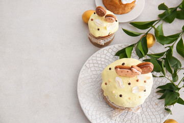 Delicious Easter cakes decorated with cookies and painted eggs on light background