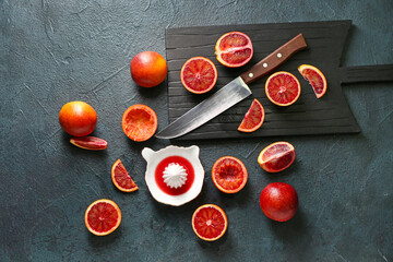 Ceramic juicer and grapefruits on dark background