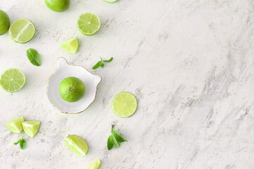 Ceramic juicer and limes on light background