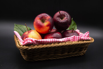 Several red apples are placed with red striped cloth in a wicker basket.Include Clipping Path.
