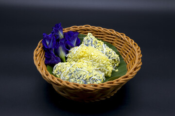Fototapeta na wymiar Pean Pap, the name of colorful Thai desserts Pean Pap, the name of colorful Thai desserts sprinkled with sugar before eating and placed in a basket. with butterfly pea flowers ,including Clipping Path