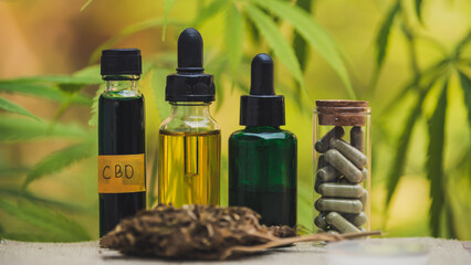 Full spectrum CBD and THC hemp oils, CBD pills and lotions on a chemically structured cannabis table.