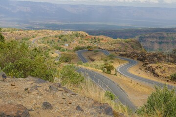Aerial view of a meandering highway against a mountain background in the Iten- Kabarnet Road, Baringo County, Kenya