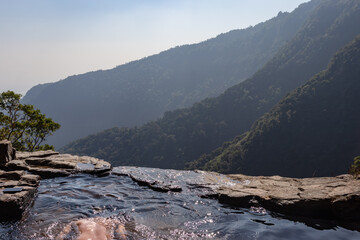 Fototapeta na wymiar man enjoying the pristine view at natural swimming pool at mountain cliff from top angles