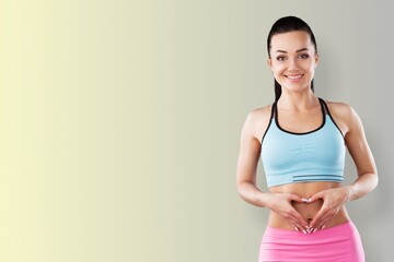 Good physical shape keeps in sportswear smiles happily concentrated away ready for training over beige. Concept Young fit fair haired woman being