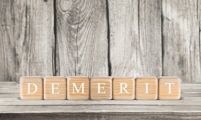 'DEMERIT' word made from wooden cube