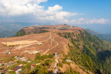 Fototapeta premium small remote village on mountain top flat bed with bright sky at morning from top angle