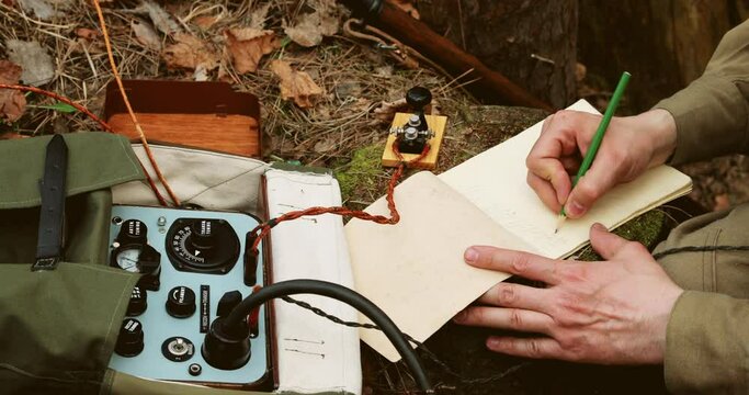 Russian Soviet Infantry Red Army Soldier In World War II using Russian Soviet Portable Radio Transceiver In Trench Entrenchment In Spring Autumn Forest. 4K. Headphones And Telegraph Key. Close Up