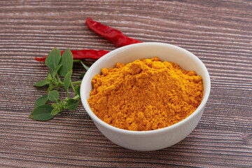 Yellow vibrant curcuma powder in the bowl